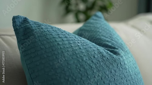 Teal textured pillow on a sofa