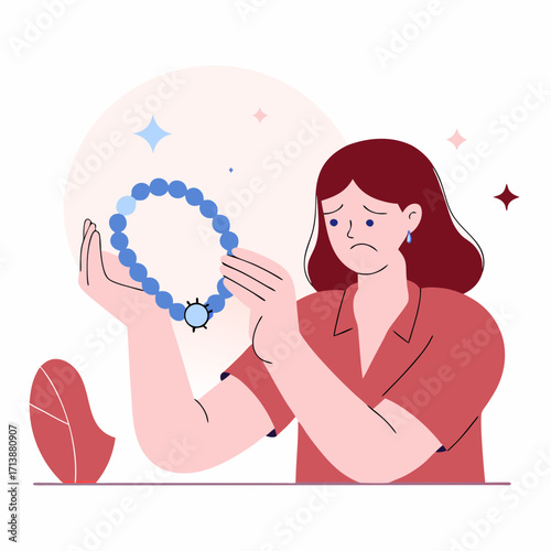 Woman looking sad while holding a broken blue bracelet
