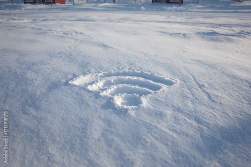 Wi-Fi symbol carved into fresh snow on a sunny winter day, concept of connectivity in remote cold locations