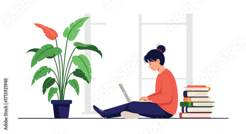 A young person works on a laptop next to a plant and a stack of books.