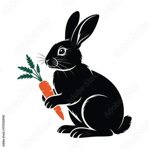Black rabbit holding a fresh orange carrot with green leaves isolated on white background