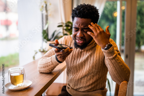 Foto A young black man sits at the bar, casually dressed