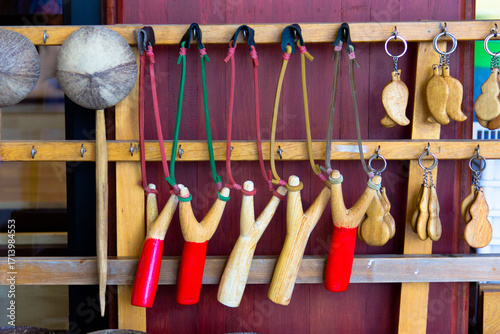 Handcrafted wooden slingshots and traditional souvenirs hanging on display, showcasing rustic craftsmanship, cultural heritage, and nostalgic charm, perfect for vintage decor or collection.