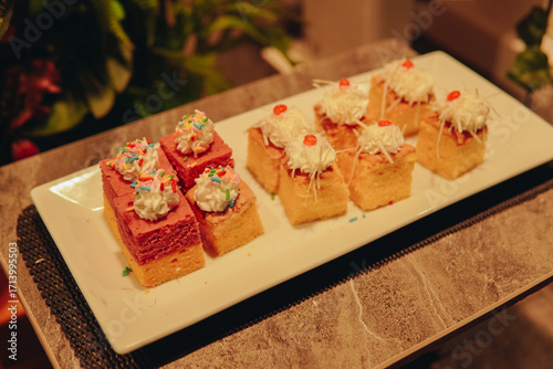 Plate of assorted desserts include a variety of cakes, sliced cakes with toppings.