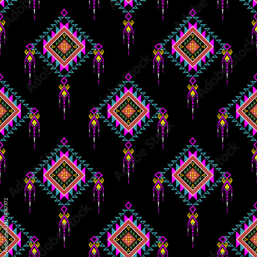 Vibrant neon geometric tribal pattern with diamond and triangle motifs on a black background, featuring magenta, turquoise, and pink accents.