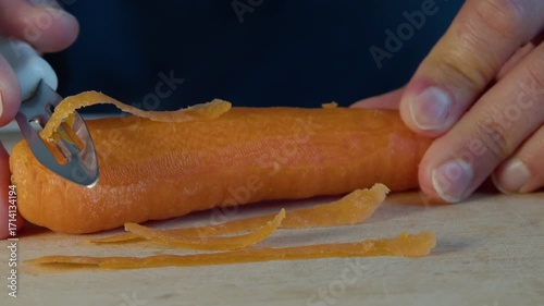 Mans hands peeling and carrot