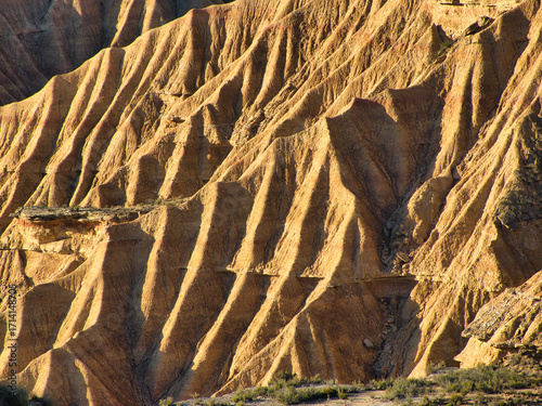 Golden hour light on detailed badlands rock formation - Striking abstract patterns of a unique arid landscape texture, perfect for travel, nature, and geology themes.