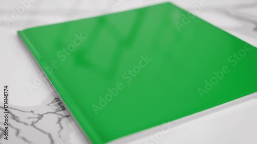 Close-up of a sleek, reflective green glass panel placed on a luxurious white and gray veined marble countertop, creating a modern aesthetic