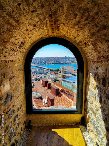 Photography Scenic view of Istanbul and the Golden Horn through an old stone window in Galat