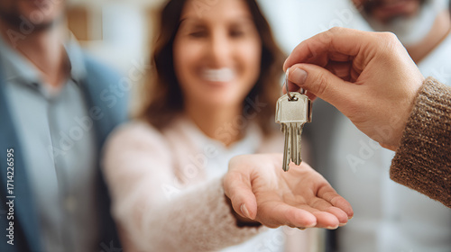 Keys handed to smiling couple signify new home ownership