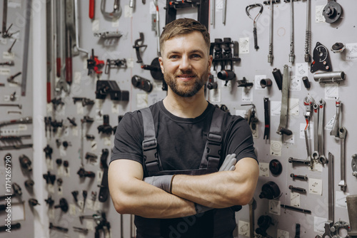 Auto mechanic smiling posing in professional workshop