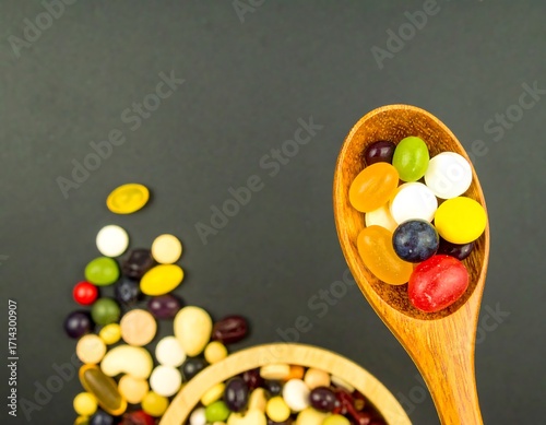Assorted pills and supplements in wooden spoon and bowl