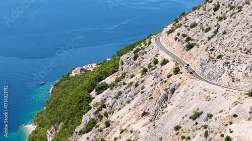 An epic summer road trip adventure on a winding cliffside road with majestic mountains and the deep blue Adriatic