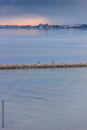 Glimpse of the Dam of San Nicolò on the Venice Lido at sunset, Italy.