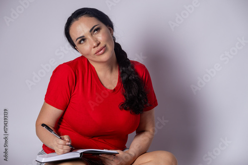 Foto Woman sitting on floor writing