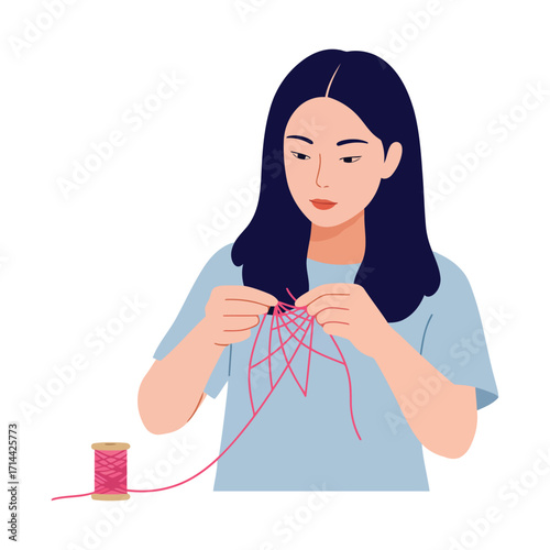A young woman with dark hair concentrates on a crafting project, weaving pink thread into a star-like pattern.