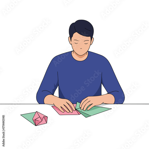 Person carefully folding origami with colorful paper on a white table surface