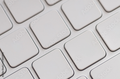 A sleek, modern keyboard with unlabeled white chiclet keys arranged in a perfect geometric grid, creating an abstract background for technology and design themes.