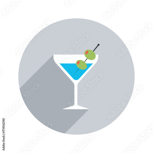 An ice cold turquoise martini glistening in a crisp white glass punctuated with two green olives against a neutral gray