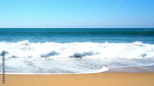 Wallpaper Mural Gentle ocean waves roll onto a pristine sandy beach under a clear blue sky. Torontodigital.ca