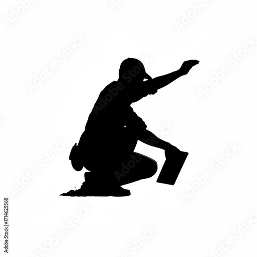 Silhouette of worker crouching and blowing dust off slab isolated on white background