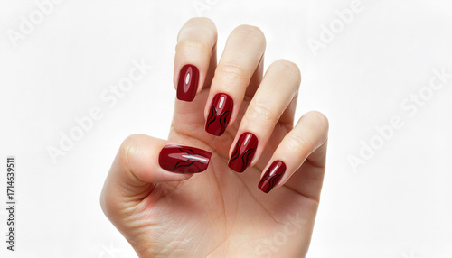Woman's hand showcasing elegant red nail polish with design patterns  