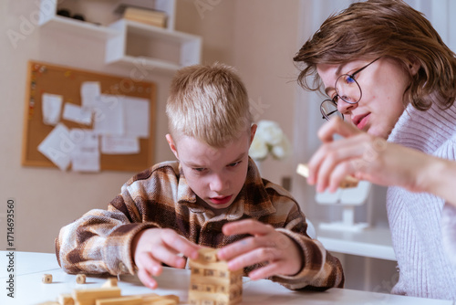 A mother and her son with hearing aids share a joyful moment playing board games together. A heartwarming scene of inclusive family bonding, love, and adaptive play