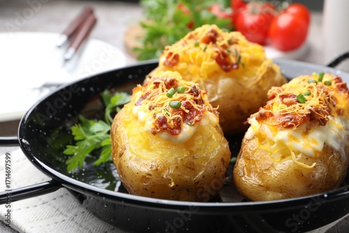 Cuadro en lienzo Tasty stuffed baked potatoes in baking dish on table, closeup