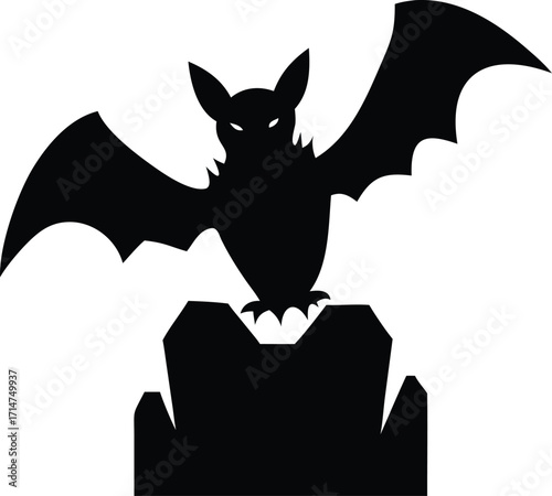 Silhouette of a black bat with outstretched wings perched on a tombstone