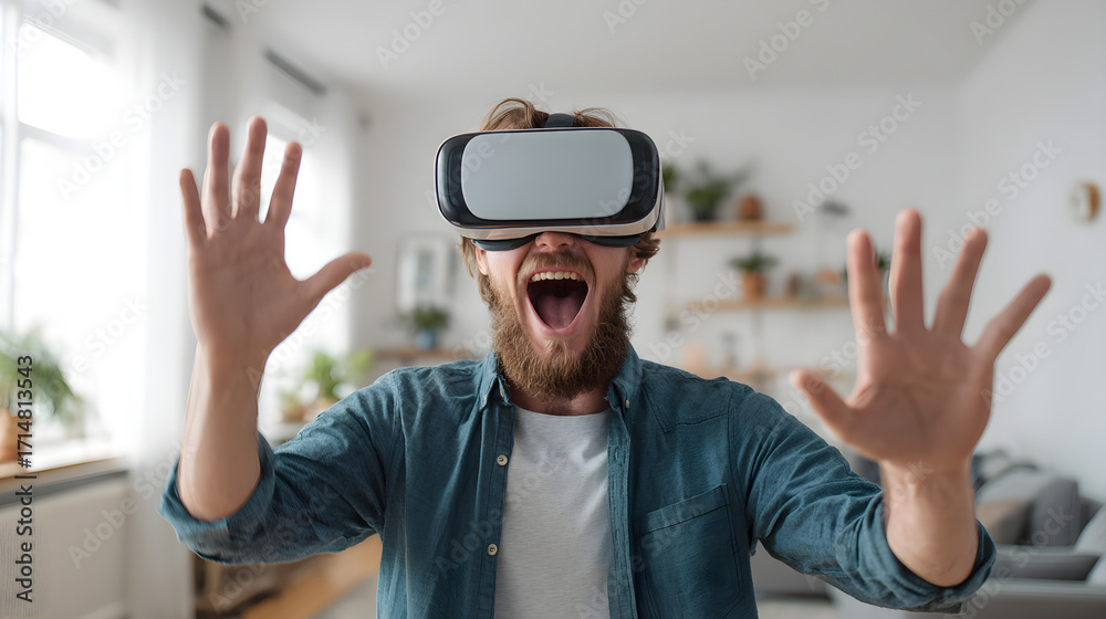 Naklejka premium Excited man wearing virtual reality headset, experiencing immersive technology in modern living room