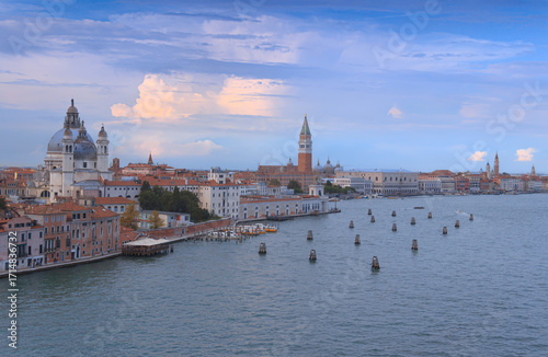 Venice cityscape from the Giudecca Canal: aerial view with a glimpse of Santa Maria della Salute with the Punta della Dogana, St. Mark's Campanile and the Doge's Palace in Italy.