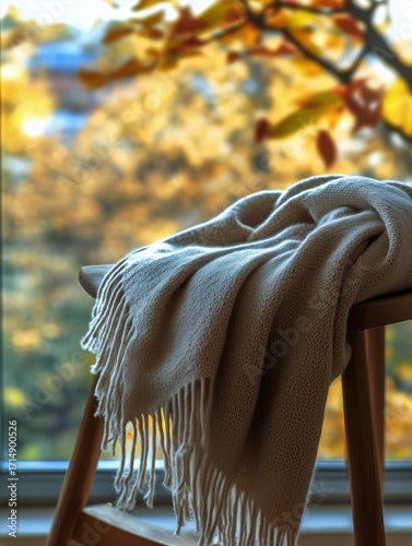 Cozy Scarf Draped Over Wooden Chair by Window With Autumn Scenery.