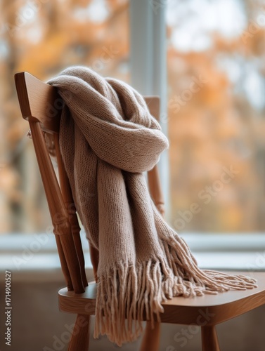 Cozy Scarf Draped Over Wooden Chair by Window With Autumn Scenery