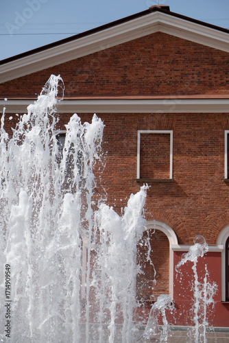 a fountain against the backdrop of a red brick building