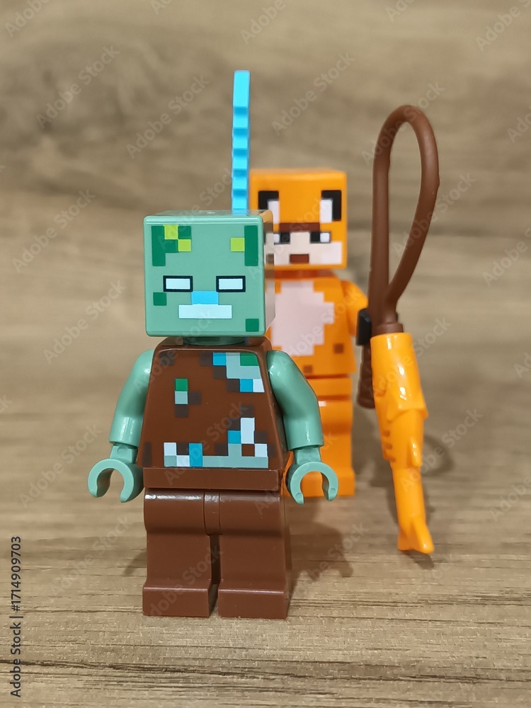 Naklejka premium Whimsical block figures a pink pig-like character with a golden weapon and a grey animal holding a fresh carrot, posed on wood, symbolizing fantasy play and imaginative adventure