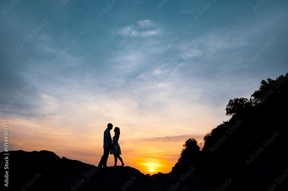 Fototapeta premium Romantic Sunset Silhouette of a Couple on a Scenic Hilltop