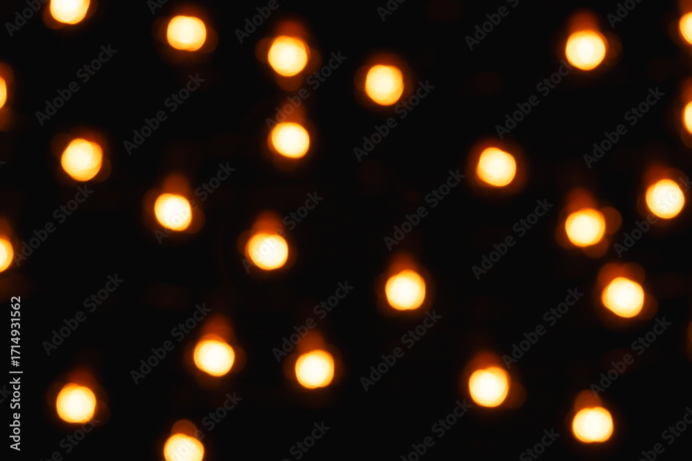Obraz premium Blurred lights of electric garland, yellow warm light