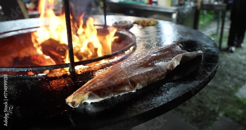 Large piece of red fish grilling at a street food festival