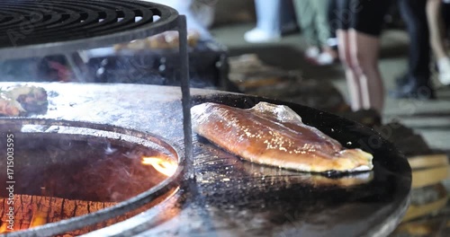 Large piece of red fish grilling at a street food festival