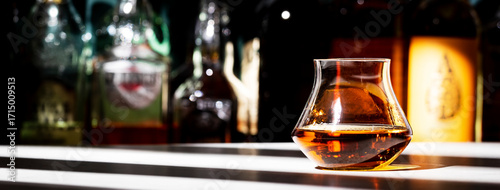 Obraz  z motywem Bourbon or whiskey glass on dark green background with strong alcoholic drinks set. Spirits, liqueurs, distillates etc. in glasses and bottles