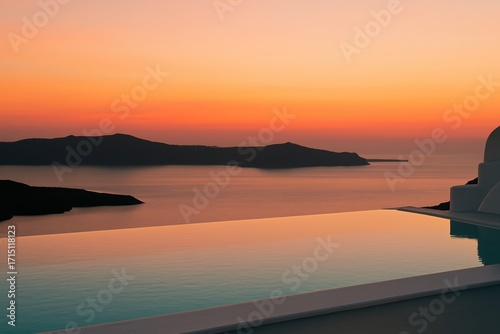 Infinity pool overlooking sea and islands at sunset in coastal resort
