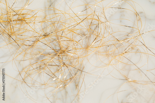 mess, tangle of golden thread on white marble