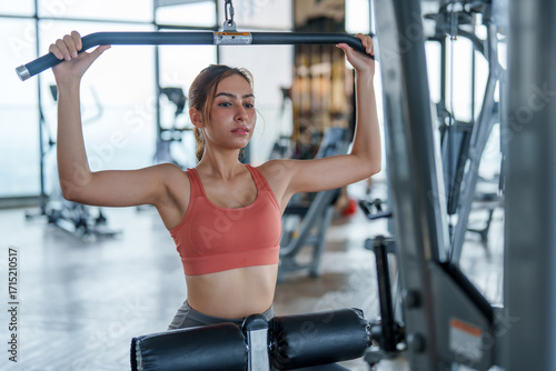 Fotografía Woman engages in focused gym exercise, showcasing her dedication to fitness and wellness