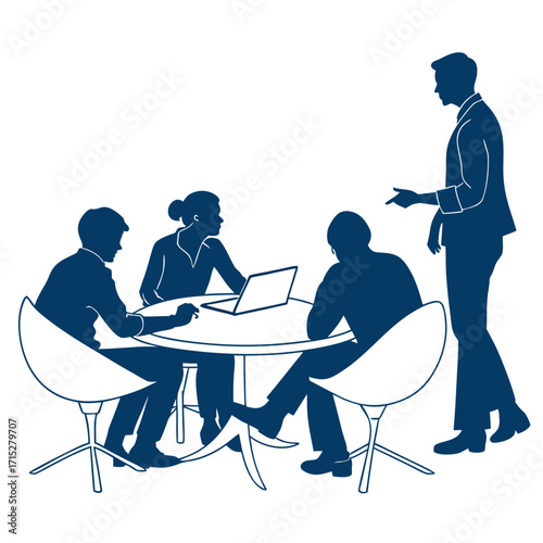 Business team collaborating around a table with a laptop while a colleague stands and gestures during a meeting