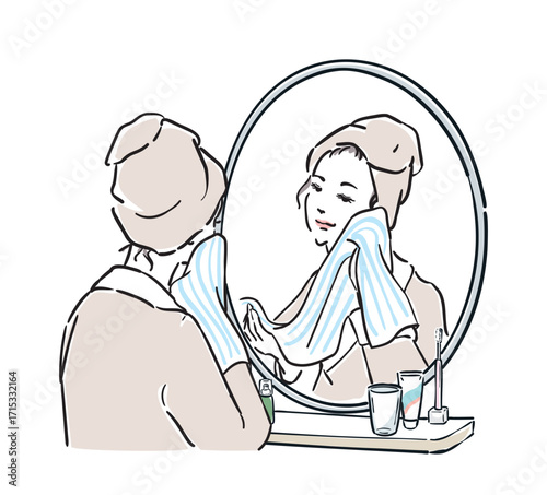 鏡の前に立つバスローブ姿の女性　洗顔