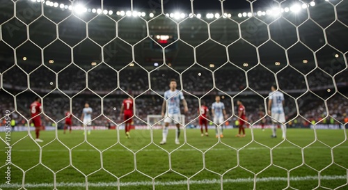 Football Match Action Through Goal Net. Soccer Players on Field in Stadium. Professional Game Perspective.