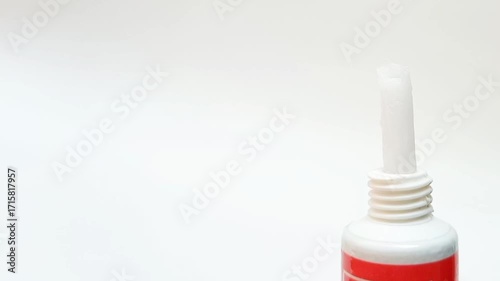 White cream coming out of a tube on white background, medical, cosmetic or skincare product
