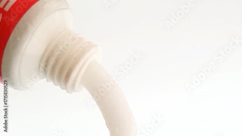 White cream coming out of a tube on white background, medical, cosmetic or skincare product. close up