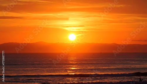 Fiery Sunset over Ocean and Distant Mountains