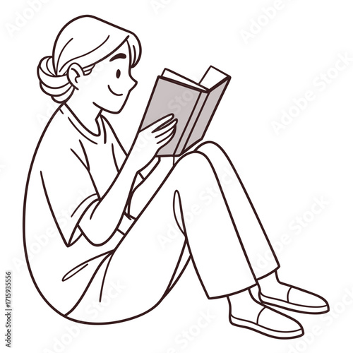 Young woman sitting cross legged on a white background reading a book with a smile